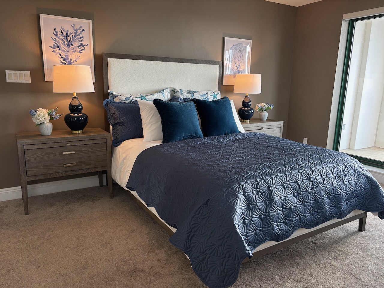 Elegant master bedroom with navy blue velvet bedding and accent pillows